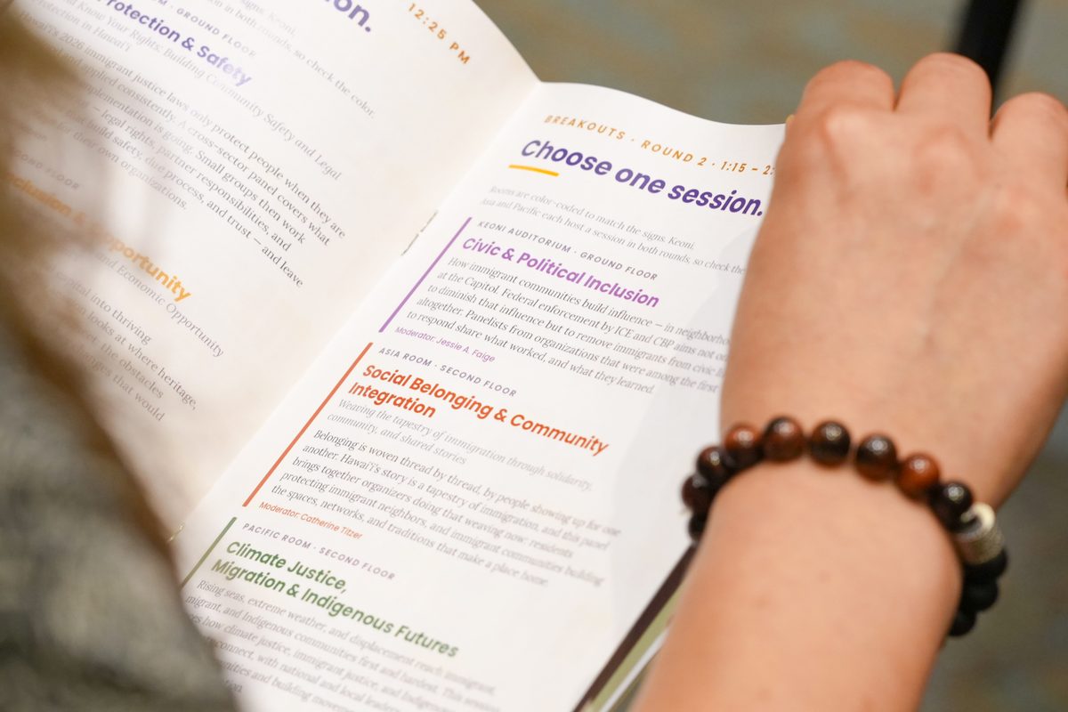 Hands holding the program open to the breakout sessions page
